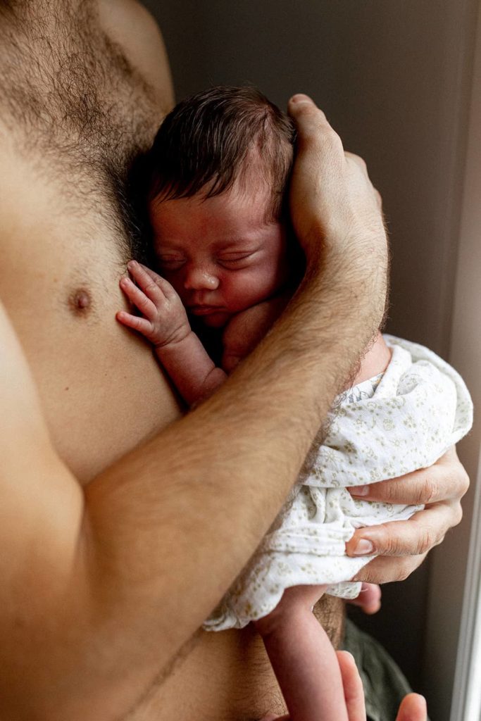 photo d'un nouveau-né tout juste né en contact peau à peau avec son père