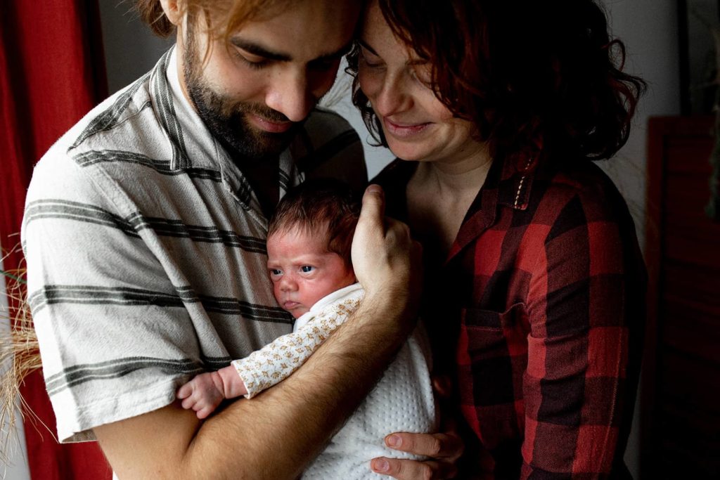 photo de famille heureuse avec un nouveau-né, entouré de ses parents souriants
